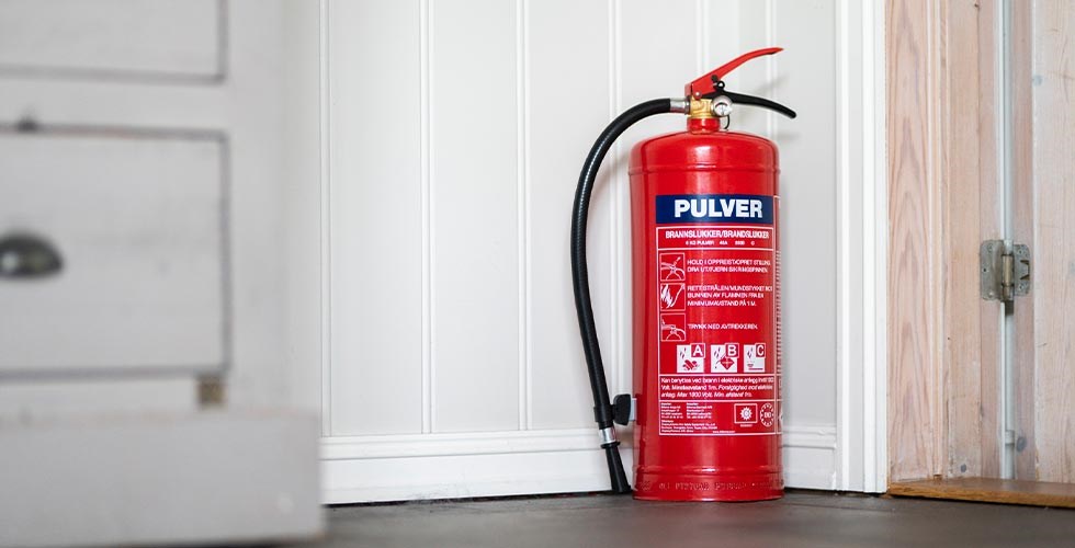 Brandslukker fra Biltema stående i en stue.