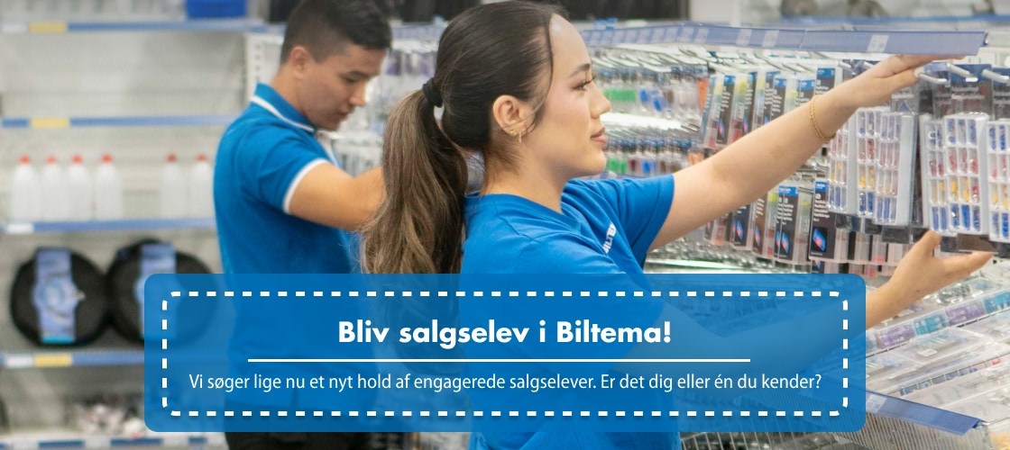 To Biltema-medarbejdere og elever i blå uniformer arbejder med vareopfyldning på butikshylder i et lyst butiksområde.