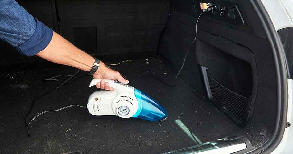 Biltema car vacuum cleaner is vacuuming the boot of a car.
