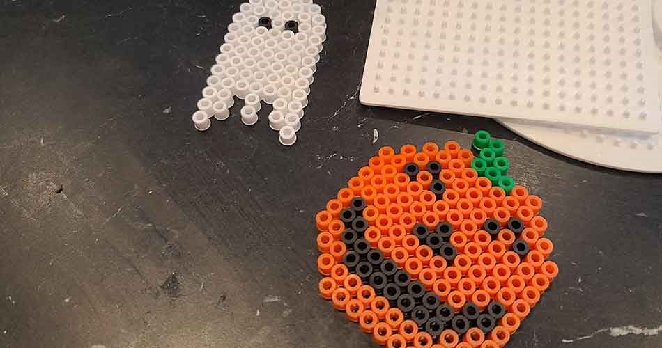 Halloweenmotiver af perler med græskar og spøgelse på perleplader.