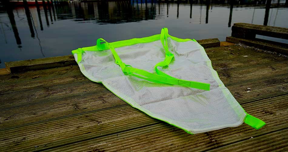 Hvidt drivanker fra Biltema med fluorescerende grønne kanter liggende på en træbro ved havnen.