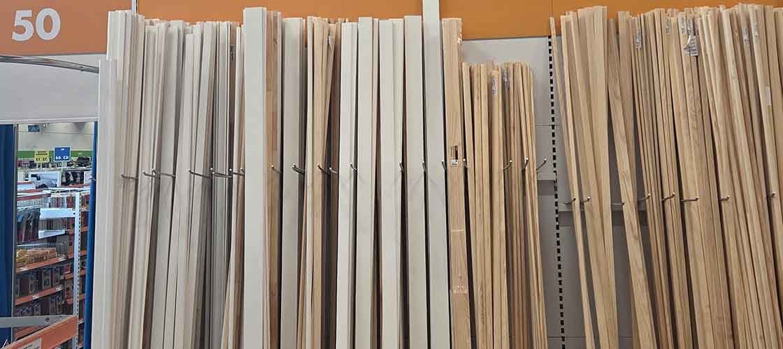 Butikshylder med lodret opstillede træ- og hvide fodlister.