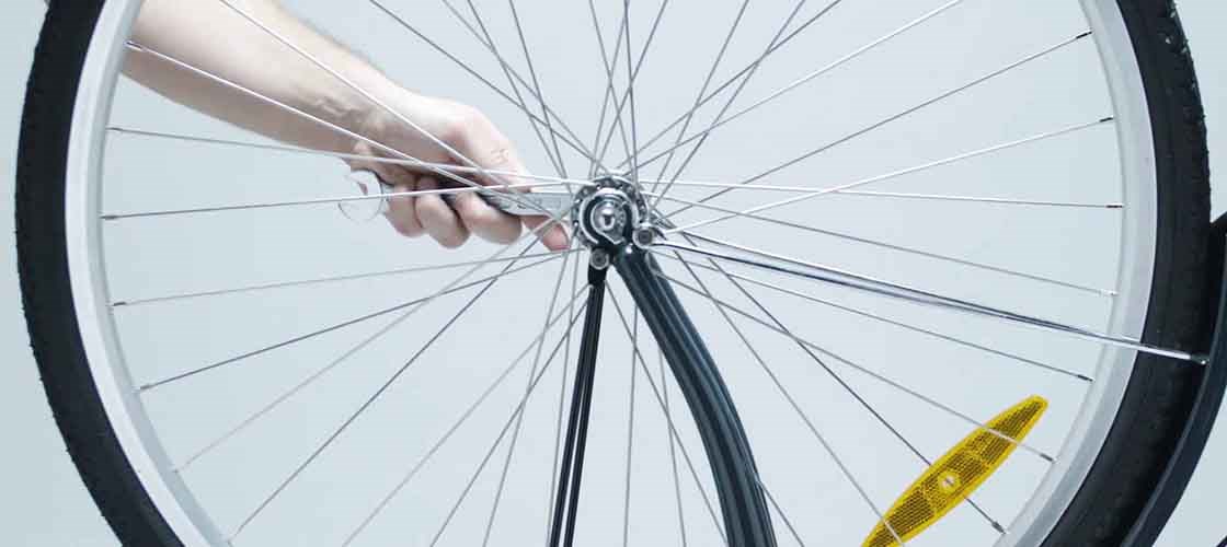 Adjustment of bicycle wheels using a Biltema open-end wrench when installing the front wheel on a bicycle.