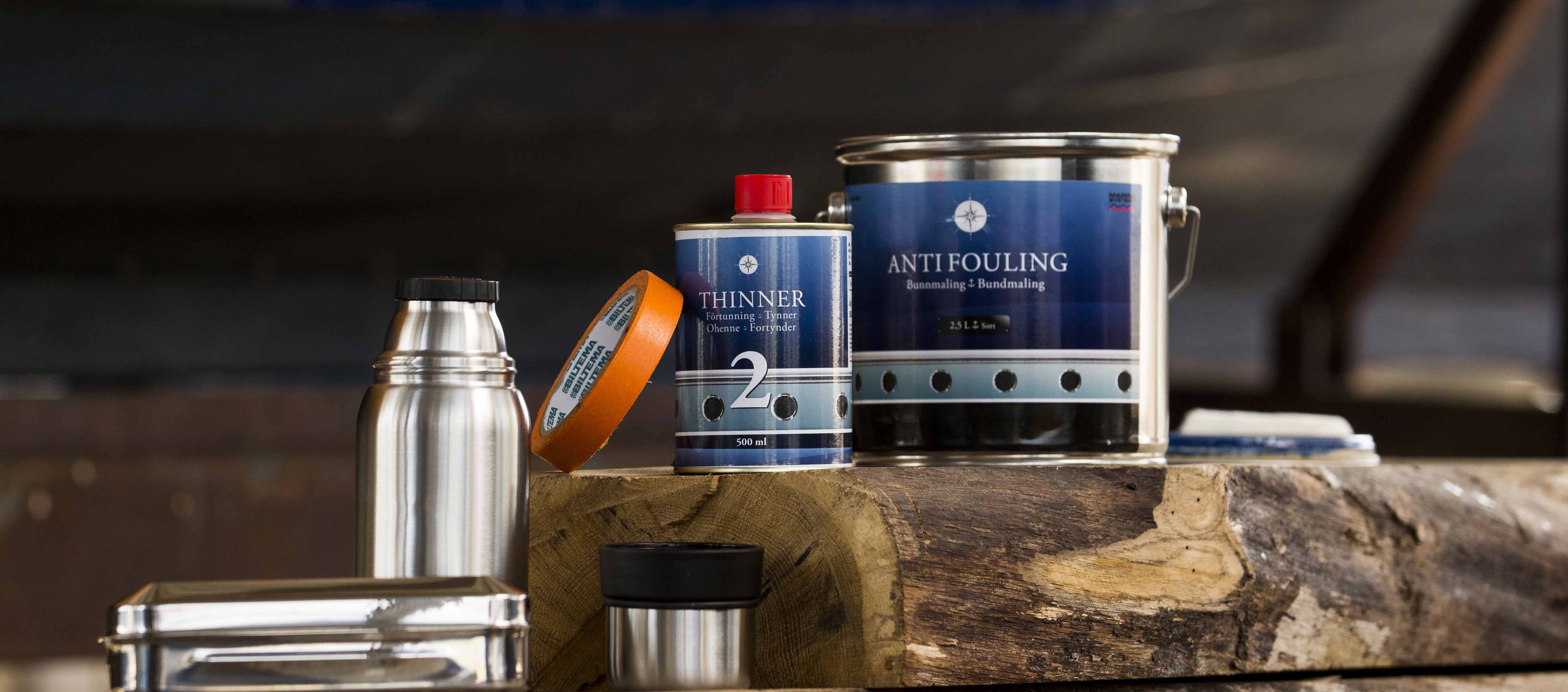 Antifouling paint and painting equipment standing next to a boat hull before painting the bottom