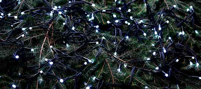 Nærbillede af en mørkegrøn juleguirlande med små, kolde hvide LED-lys, der skaber en hyggelig og festlig stemning.