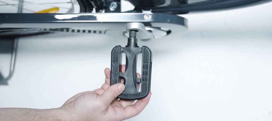 Installing a bicycle pedal using Biltema tools while fitting the pedal onto the bike crank.