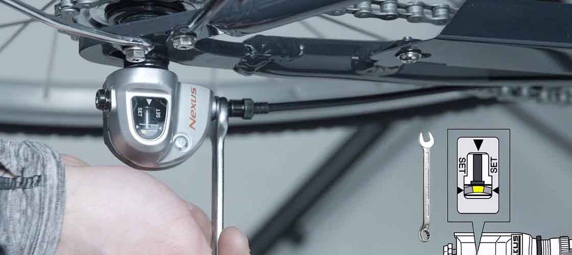 Adjusting bicycle gears using a Biltema spanner while installing hub gear and chain on a bike.