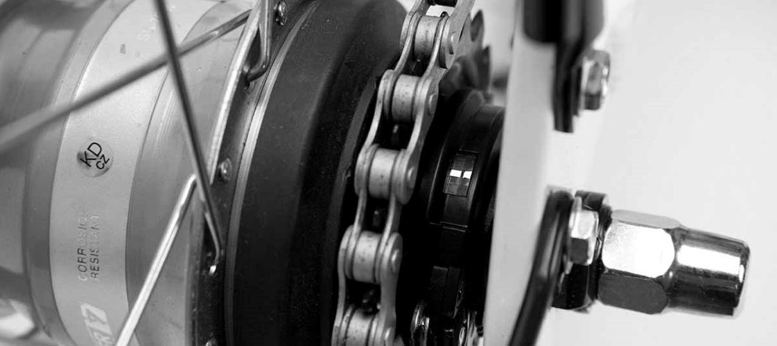 Close-up of a bicycle's gear system and chain. The image is in black and white and shows the gears and chain clearly in focus.